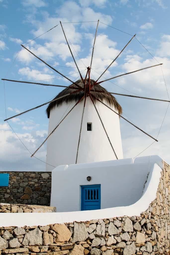 A Traditional Windmill Under Blue Sky with White Clouds