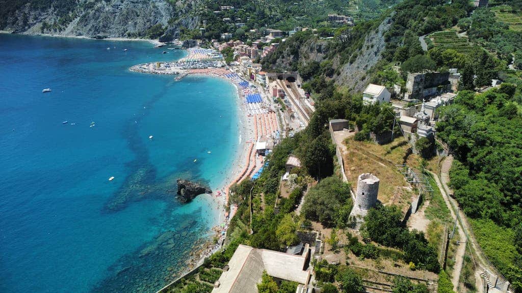 best beaches in cinque terre italy The beach and the blue water are surrounded by trees Monterosso